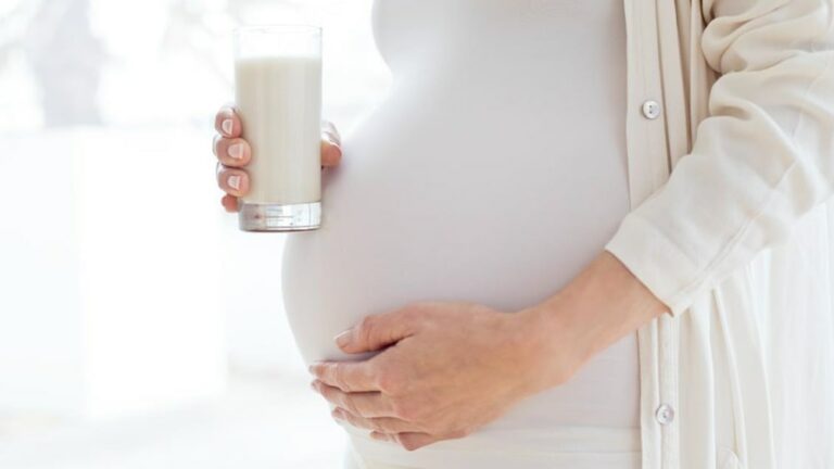 임산부 유제품 섭취 관련 흰 옷을 입은 임신부가 우유가 들어 있는 잔을 들고 있는 이미지