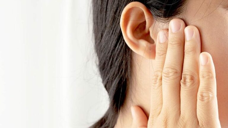 귀 이명 관련 귀 근처 얼굴 부위에 손을 대고 있는 여성의 옆모습을 클로징한 이미지