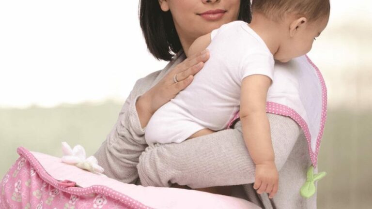 신생아 트림 관련 아기가 여성 품에 안겨 있고 여성이 아기 등을 두드리고 있는 이미지