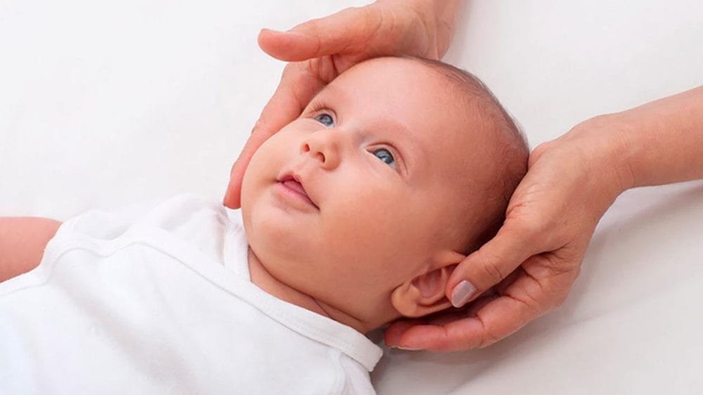 아기 목 가누기 관련 누워 있는 아기의 목을 양손ㄴ으로 받치고 있는 이미지