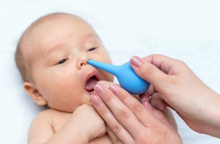 신생아 코막힘 관련 파란 스포이드로 아기 코에 식염수를 넣고 있는 이미지