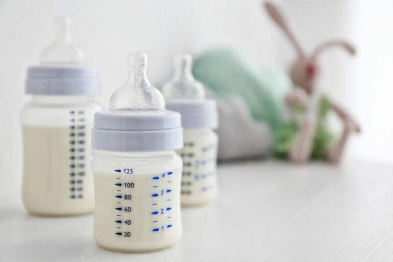 신생아 수유량 관련 테이블 위에 아기 젖병 세개가 놓여져 있는 이미지