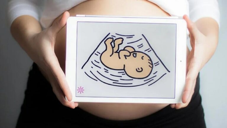 임신부 배 부분에 아기 이미지가 있는 태블릿을 갖다 댄 모습
