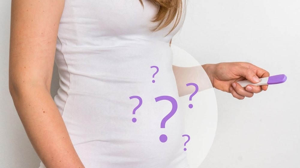 임신 잘되는 법 관련 여성 배 부분에 물음표가 있고 한손으로 임신 테스트기를 잡고 있는 이미지