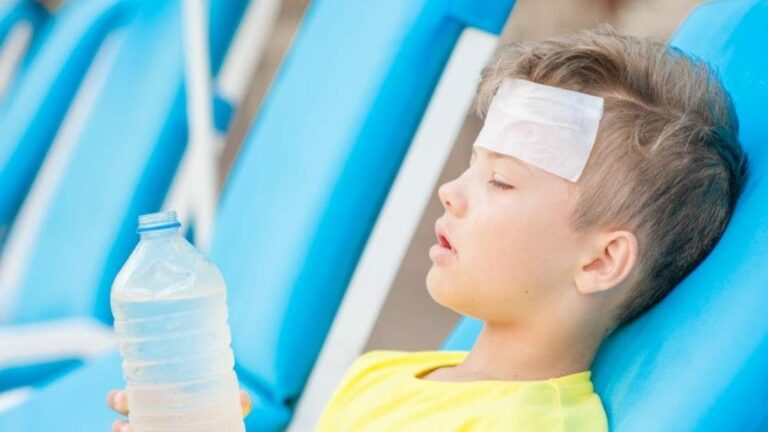더위 먹은 증상 관련 한 아이가 이마에 하얀 아이팩을 붙이고 손에 페트병을 든 채로 의자에 기대 눈을 감고 누워 있는 이미지