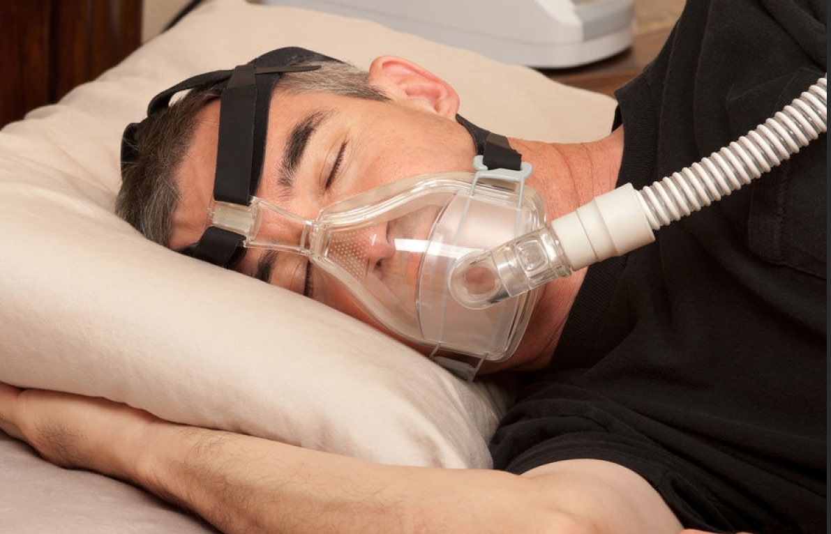 수면 무호흡증 관련 수면 보조기를 하고 자는 남성의 모습