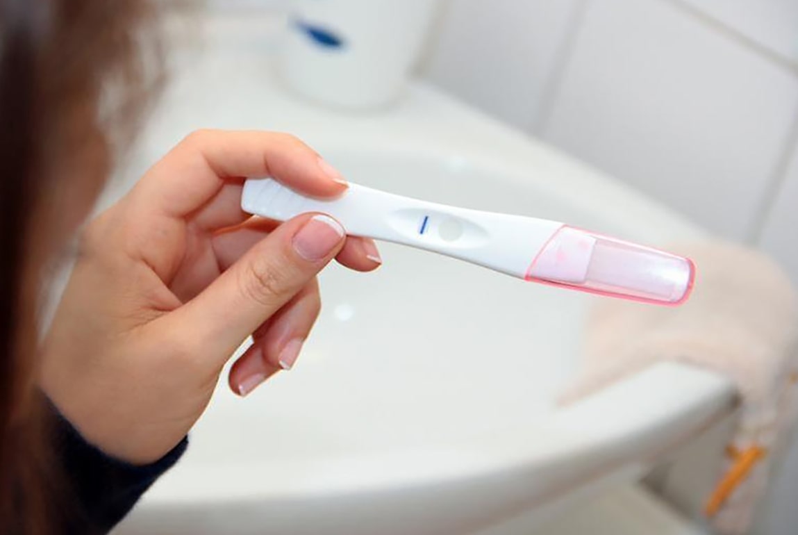 화장실에서 한줄이 나온 임신테스트기를 들고 있는 모습