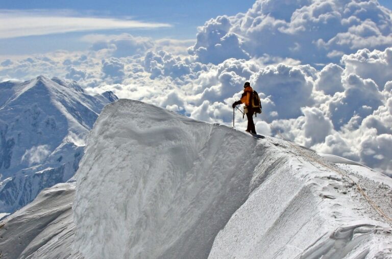 고산병 관련 눈과 구름이 둘러쌓인 설산을 오르는 사람 모습