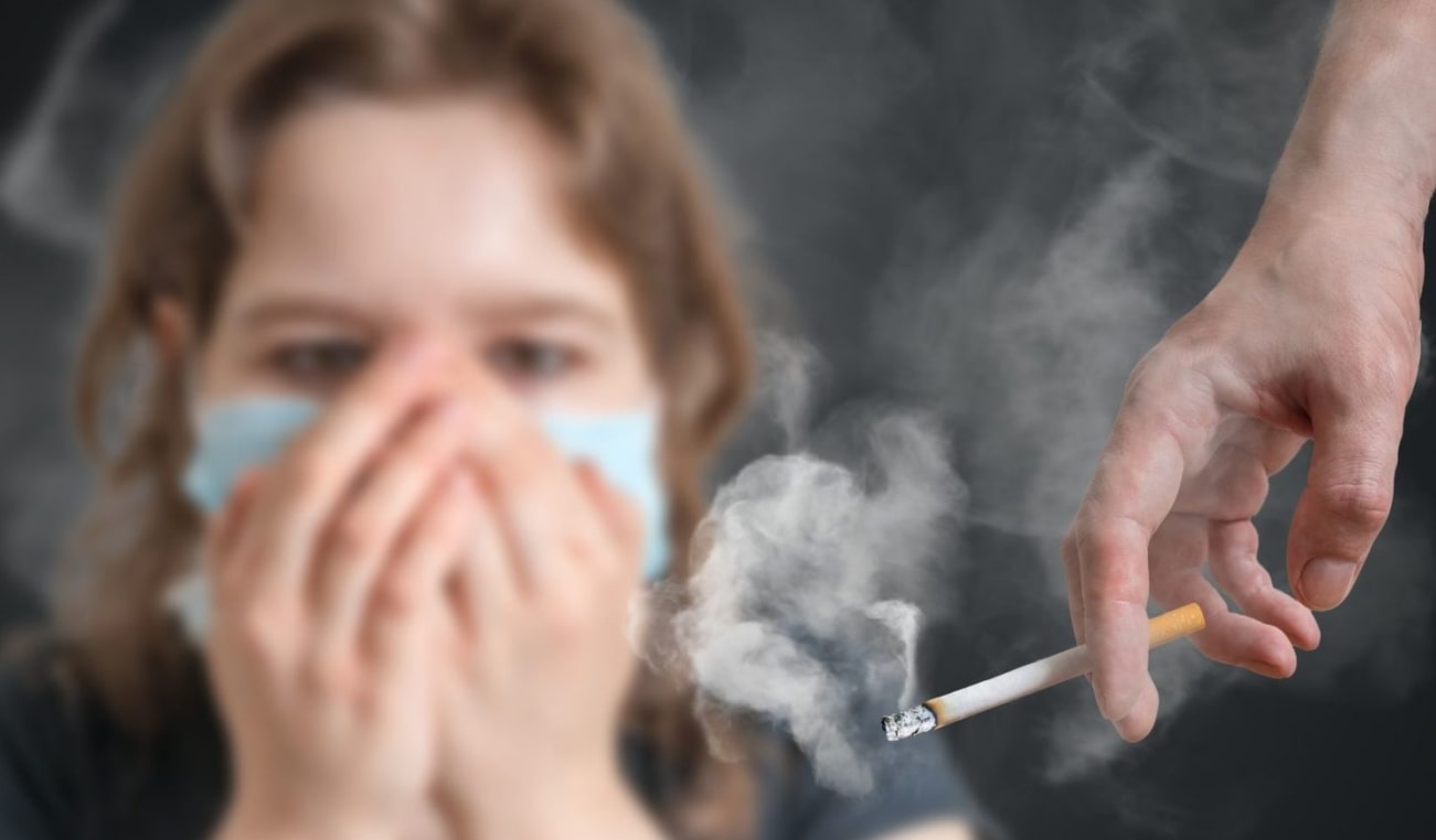연기가 나는 담배를 쥔 손 뒤에서 손수건으로 코와 입을 막고 있는 여자 모습