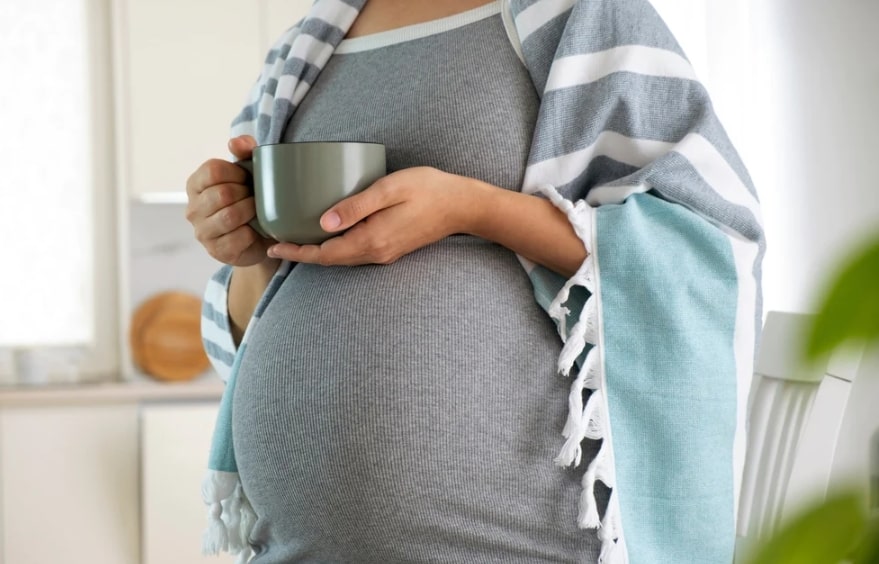 임산부 녹차 섭취 관련 임산부가 머그컵을 양 손으로 들고 서 있는 모습