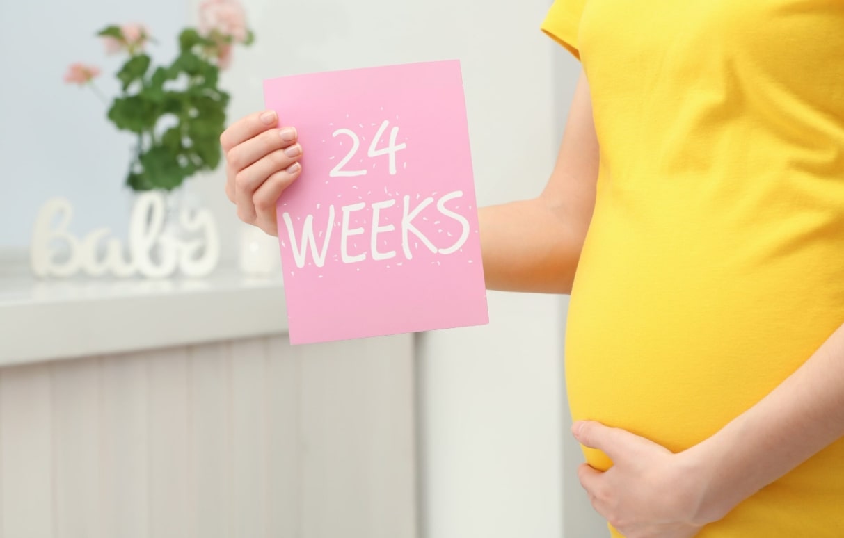 임산부 체중증가 관련 24weeks 안내판을 들고 있는 임산부 모습