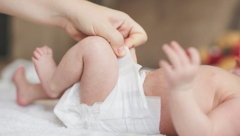신생아 대변 횟수 관련 아기 기저귀를 채우고 있는 모습